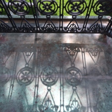 Shadow of the 1851 wrought iron railing on the copper surface of the balcony.